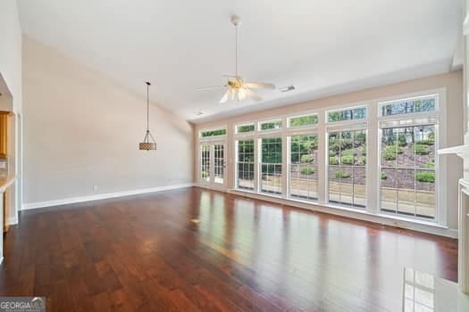 1330 Badingham Dr, Cumming, GA 30041 - unfurnished living room featuring a ceiling fan, wood finished floors, plenty of natural light, and vaulted ceiling