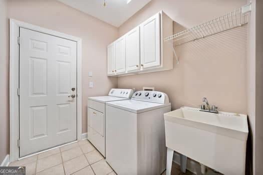 1330 Badingham Dr, Cumming, GA 30041 - laundry room featuring independent washer and dryer, cabinet space, and light tile patterned flooring
