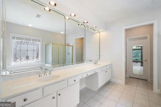 1330 Badingham Dr, Cumming, GA 30041 - bathroom with double vanity, tile patterned floors, and an enclosed shower