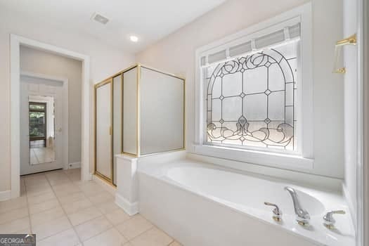 1330 Badingham Dr, Cumming, GA 30041 - bathroom featuring a bath, tile patterned flooring, and a shower stall