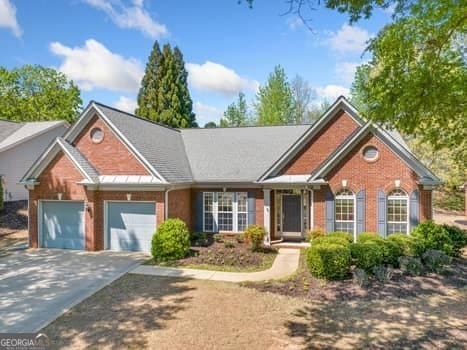 1330 Badingham Dr, Cumming, GA 30041 - view of front of house with driveway, a garage, and brick siding