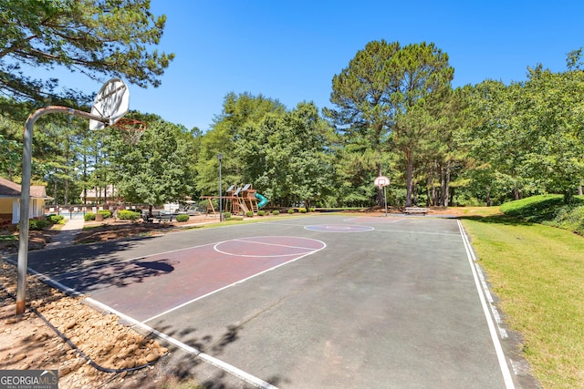 view of sport court featuring community basketball court, playground community, and a lawn