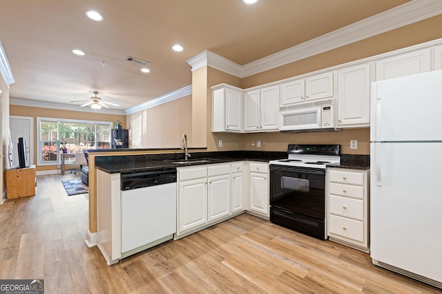 kitchen featuring visible vents, a sink, ornamental molding, white appliances, and light wood-style floors