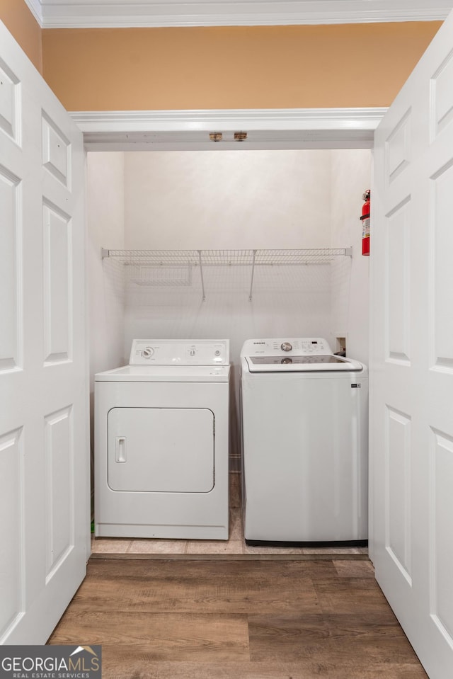 laundry room with wood finished floors, washer and dryer, and laundry area