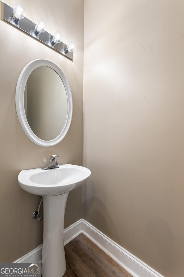 bathroom with baseboards and wood finished floors