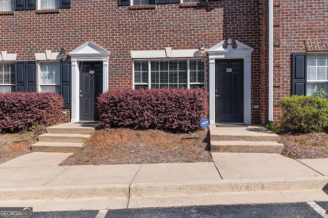 doorway to property featuring brick siding