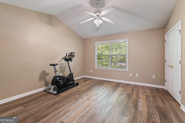 exercise room with wood finished floors, ceiling fan, baseboards, and vaulted ceiling