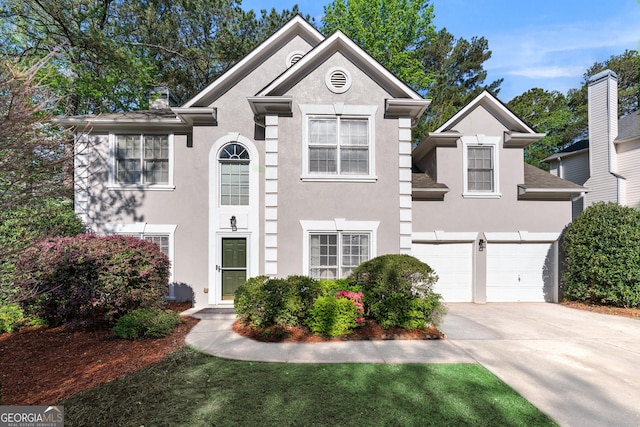 view of front of property with concrete driveway, stucco siding, and a garage