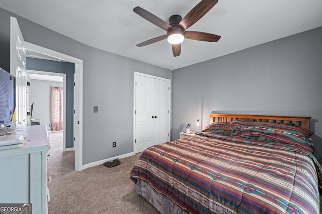 carpeted bedroom featuring a closet, attic access, baseboards, and a ceiling fan