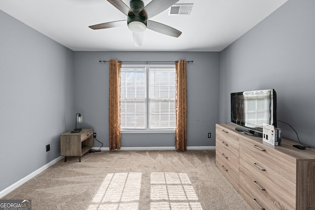 unfurnished bedroom featuring visible vents, light colored carpet, baseboards, and ceiling fan