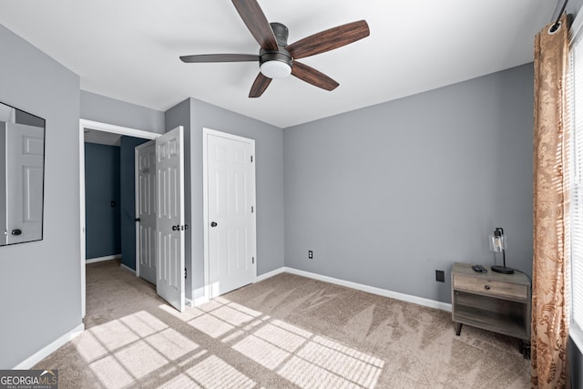 unfurnished bedroom featuring ceiling fan, light colored carpet, and baseboards
