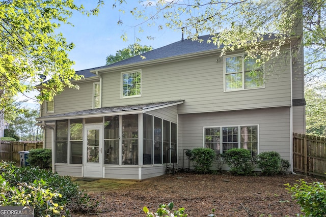 back of property featuring fence and a sunroom