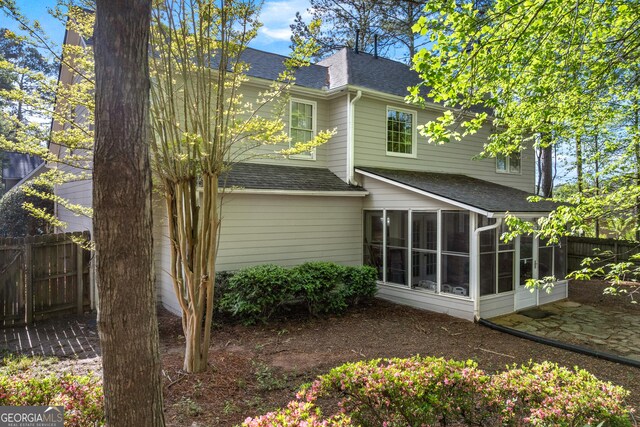 1035 Bridle Path Dr, Lawrenceville, GA 30045 - rear view of property with a shingled roof and a sunroom