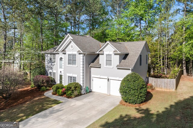 1035 Bridle Path Dr, Lawrenceville, GA 30045 - view of front facade featuring concrete driveway, an attached garage, stucco siding, roof with shingles, and view of scattered trees