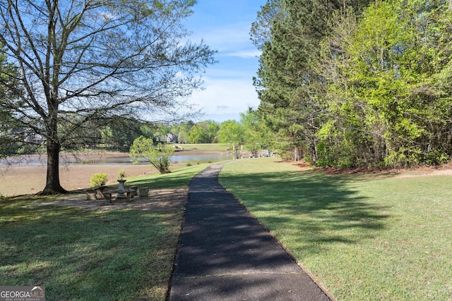 view of property's community with a yard and a water view