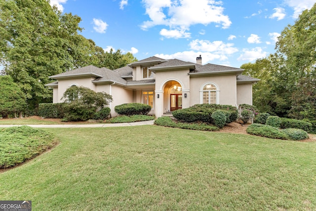 12 Arbor Shrs, Newnan, GA 30265 - view of front of home with a front yard, a chimney, stucco siding, and roof with shingles