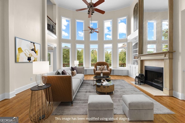 12 Arbor Shrs, Newnan, GA 30265 - living room with a ceiling fan, crown molding, a towering ceiling, wood finished floors, and a fireplace with flush hearth