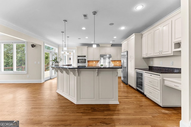 12 Arbor Shrs, Newnan, GA 30265 - kitchen with appliances with stainless steel finishes, beverage cooler, light wood finished floors, dark countertops, and crown molding