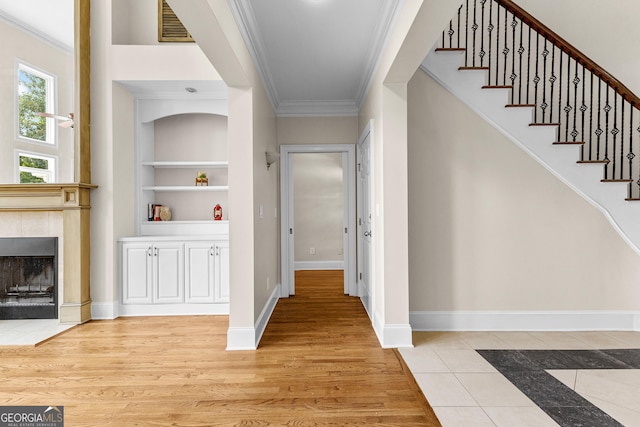 12 Arbor Shrs, Newnan, GA 30265 - foyer entrance with crown molding, stairs, a tile fireplace, and light wood-style flooring