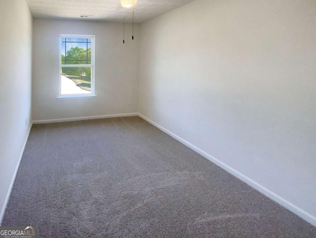 unfurnished room featuring baseboards, visible vents, and carpet floors