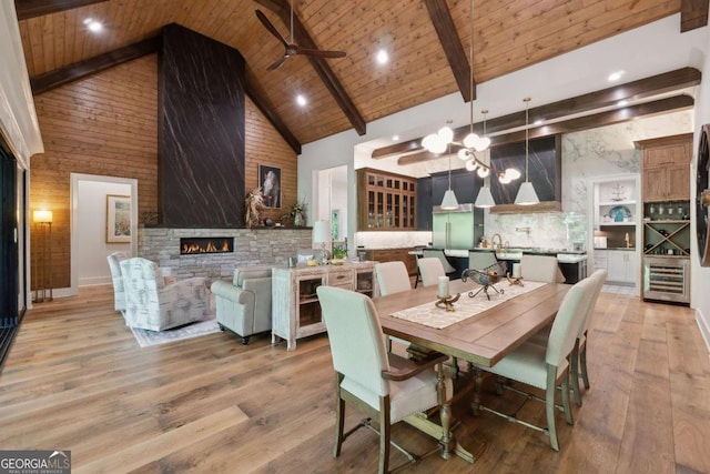 448 Golden Bear Pass, Dahlonega, GA 30533 - dining area with high vaulted ceiling, a ceiling fan, a stone fireplace, light wood-type flooring, and wooden ceiling with exposed beams