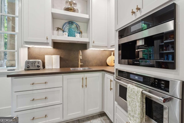 448 Golden Bear Pass, Dahlonega, GA 30533 - kitchen with a sink, stainless steel oven, open shelves, decorative backsplash, and white cabinetry