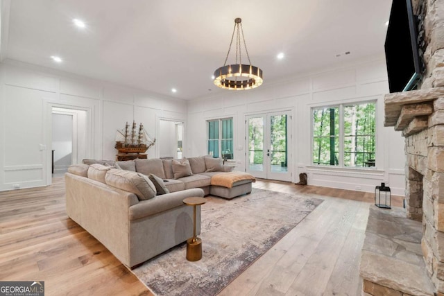 448 Golden Bear Pass, Dahlonega, GA 30533 - living area with a decorative wall, wood finished floors, french doors, a fireplace, and a chandelier