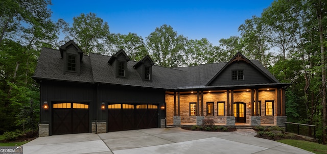 448 Golden Bear Pass, Dahlonega, GA 30533 - view of front of house featuring stone siding, driveway, roof with shingles, an attached garage, and covered porch