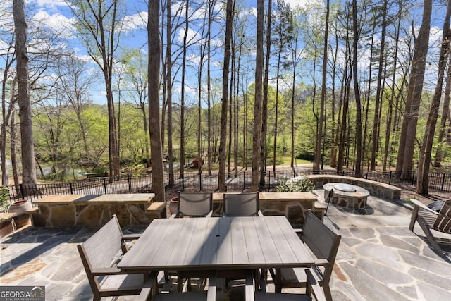 448 Golden Bear Pass, Dahlonega, GA 30533 - fenced backyard with a patio area, an outdoor fire pit, outdoor dining space, and a view of trees