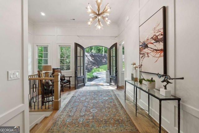 448 Golden Bear Pass, Dahlonega, GA 30533 - entrance foyer featuring a decorative wall, a chandelier, plenty of natural light, wood finished floors, and ornamental molding