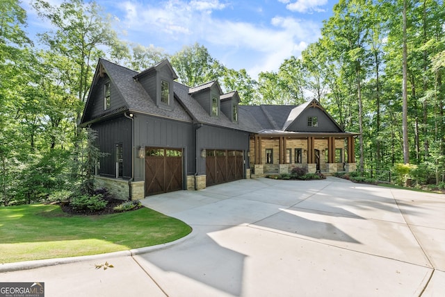 448 Golden Bear Pass, Dahlonega, GA 30533 - view of front of house featuring stone siding, an attached garage, driveway, covered porch, and roof with shingles