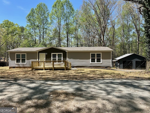 view of front of home with a wooden deck, crawl space, and an outbuilding