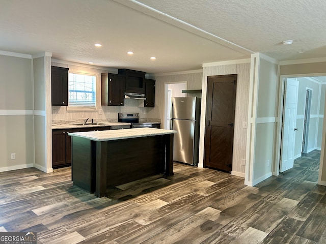 kitchen featuring stainless steel appliances, under cabinet range hood, dark wood-style flooring, and ornamental molding