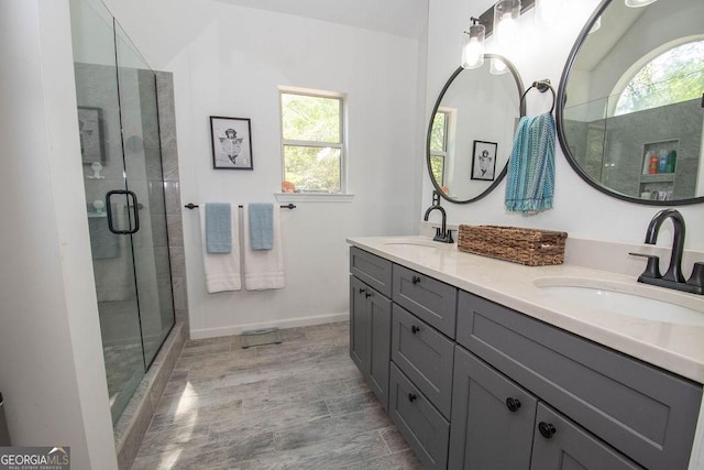 bathroom with a shower stall, a wealth of natural light, and a sink