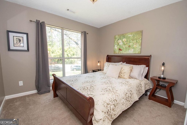 bedroom with light carpet, visible vents, and baseboards