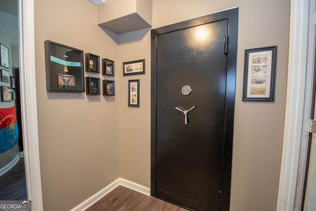hallway featuring baseboards and dark wood finished floors