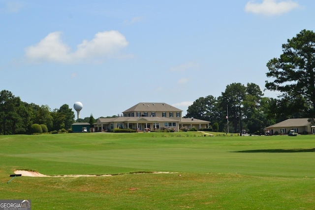 surrounding community with a yard and view of golf course