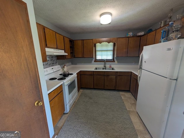 408 Railroad Ave, East Dublin, GA 31027 - kitchen featuring white appliances, under cabinet range hood, a sink, a textured ceiling, and light countertops
