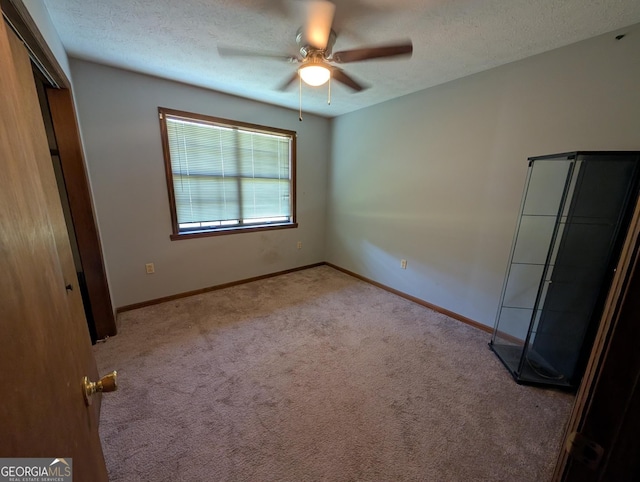 408 Railroad Ave, East Dublin, GA 31027 - unfurnished bedroom with carpet, a textured ceiling, a ceiling fan, baseboards, and a closet