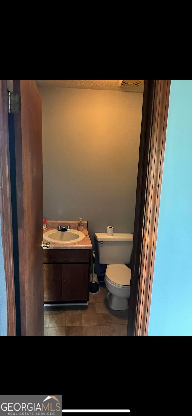 408 Railroad Ave, East Dublin, GA 31027 - half bathroom with toilet, tile patterned floors, and vanity