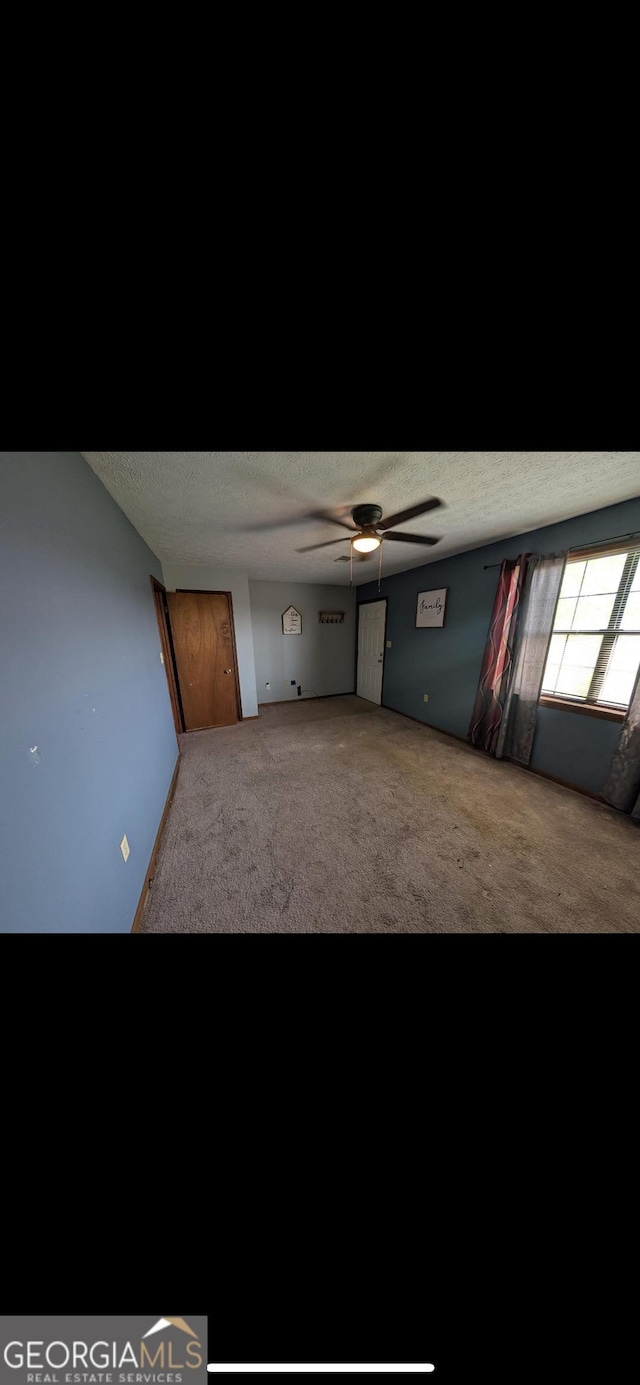 408 Railroad Ave, East Dublin, GA 31027 - spare room featuring carpet floors, a textured ceiling, and a ceiling fan