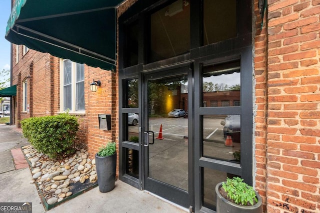 entrance to property featuring brick siding