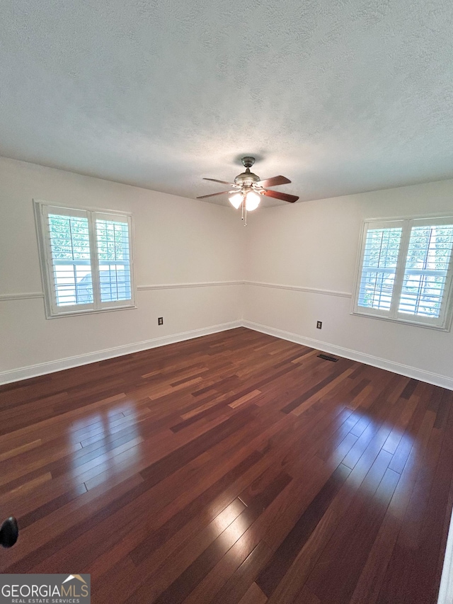 3411 Ponderosa Rd, Portal, GA 30450 - empty room with a textured ceiling, plenty of natural light, dark wood-type flooring, and ceiling fan