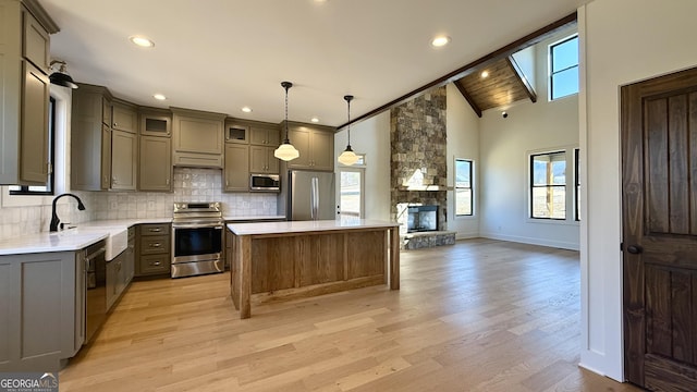 kitchen featuring stainless steel appliances, tasteful backsplash, a sink, and a healthy amount of sunlight