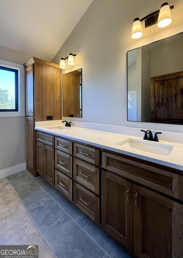 full bathroom with double vanity, a sink, tile patterned flooring, and vaulted ceiling