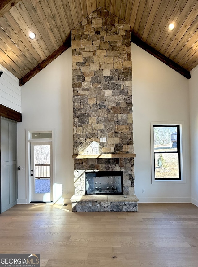 unfurnished living room with high vaulted ceiling, a fireplace, wooden ceiling, and wood finished floors
