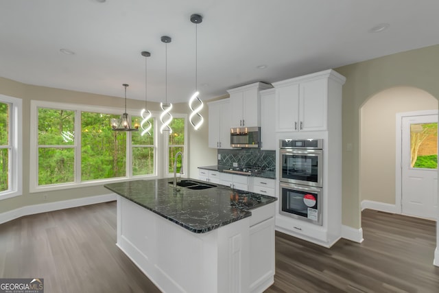 6048 Golf View Xing, Locust Grove, GA 30248 - kitchen with appliances with stainless steel finishes, arched walkways, dark wood-style floors, white cabinets, and backsplash