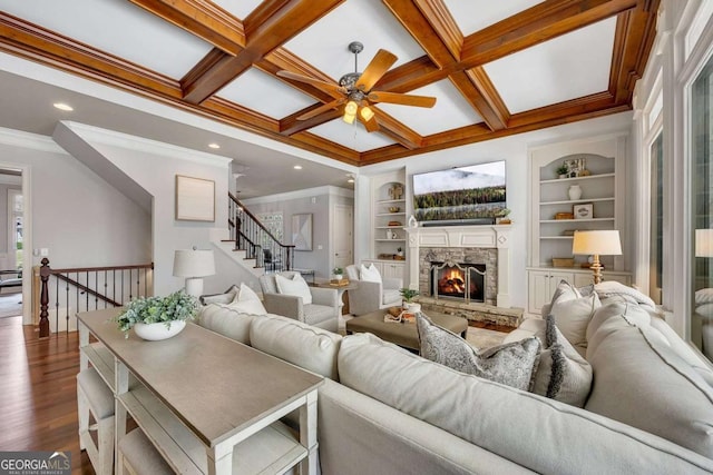 921 Accipiter Way, Ball Ground, GA 30107 - living area with a ceiling fan, a stone fireplace, dark wood-type flooring, ornamental molding, and built in shelves