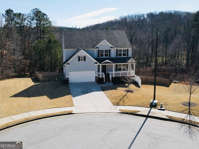 121 Birch River Ct, Dallas, GA 30132 - traditional-style house featuring concrete driveway, a view of trees, an attached garage, a front lawn, and covered porch