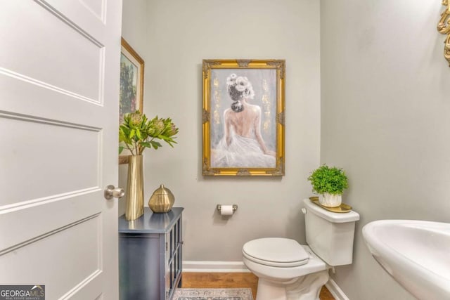 1302 Gardenia Ct, Villa Rica, GA 30180 - half bath with baseboards, a sink, toilet, and wood finished floors